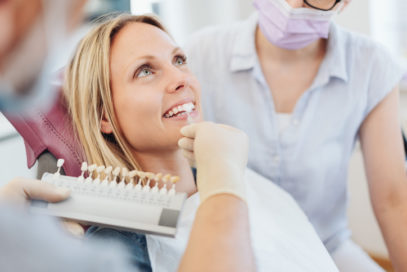 Doctor matching tooth color for dental restoration